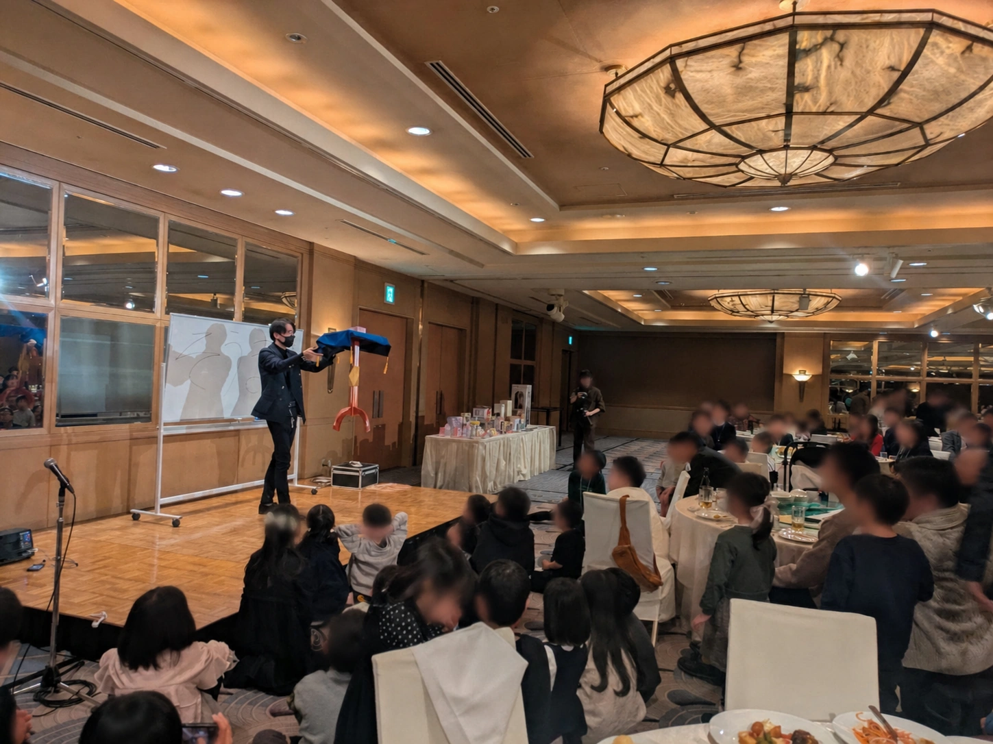子どもと大人の前でキッズショーを行うKOKI